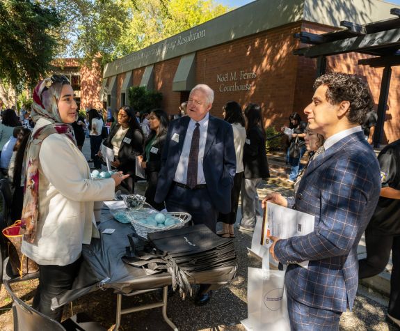 students outside talking to an employer