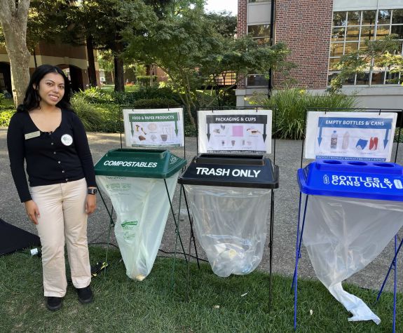 a student stands next to a waste sorter