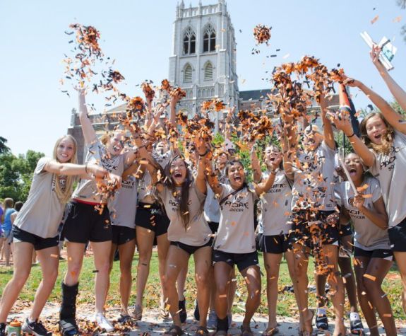 Many students cheering and throwing confetti