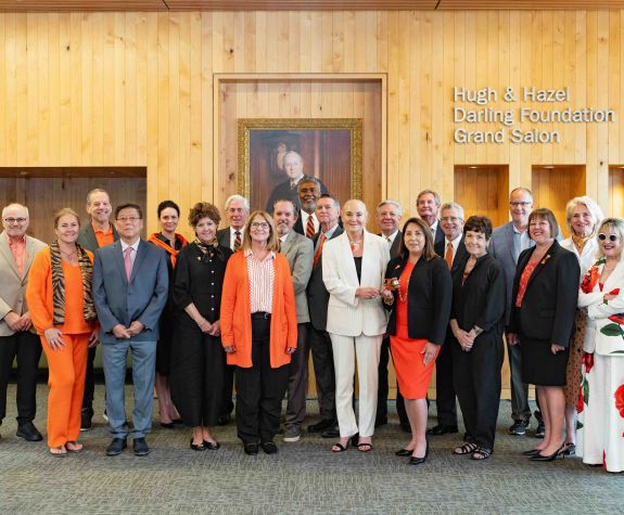 members of the Pacific Board of Regents stand together in a wood-paneled room