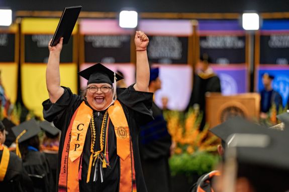 Woman with diploma at College of the Pacific ceremony