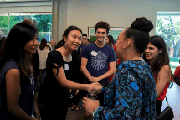 Students and alumni shake hands
