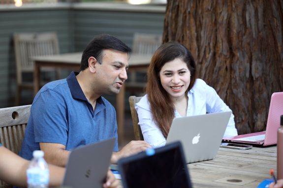 Two students look at a laptop