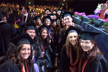 Dugoni students in regalia sitting together
