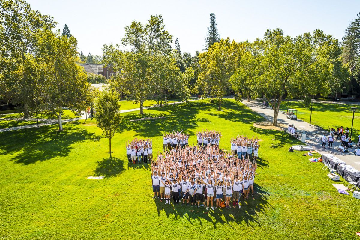Students standing together in paw print formation
