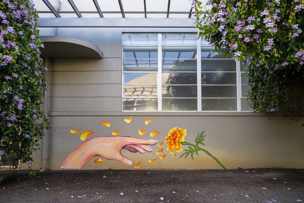 art mural of hand reaching a flower