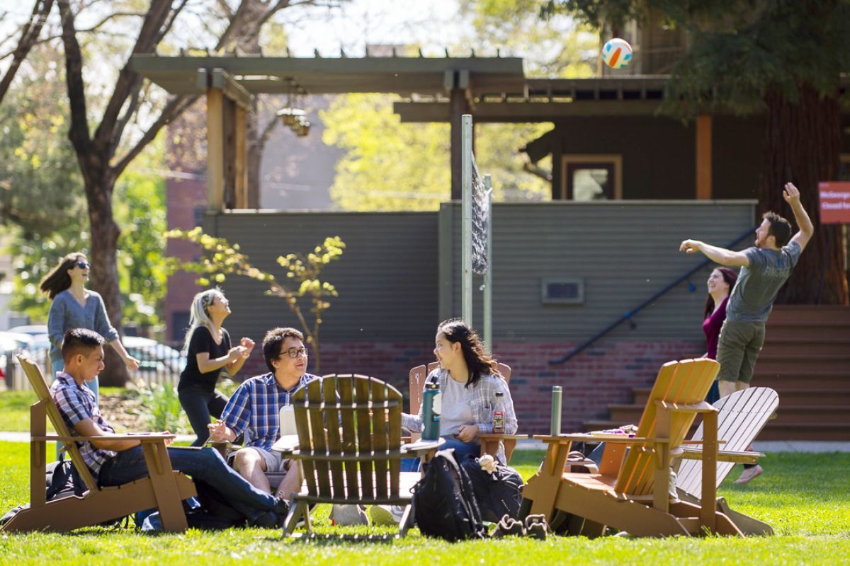students relax outside on the lawn on the Sacramento campus
