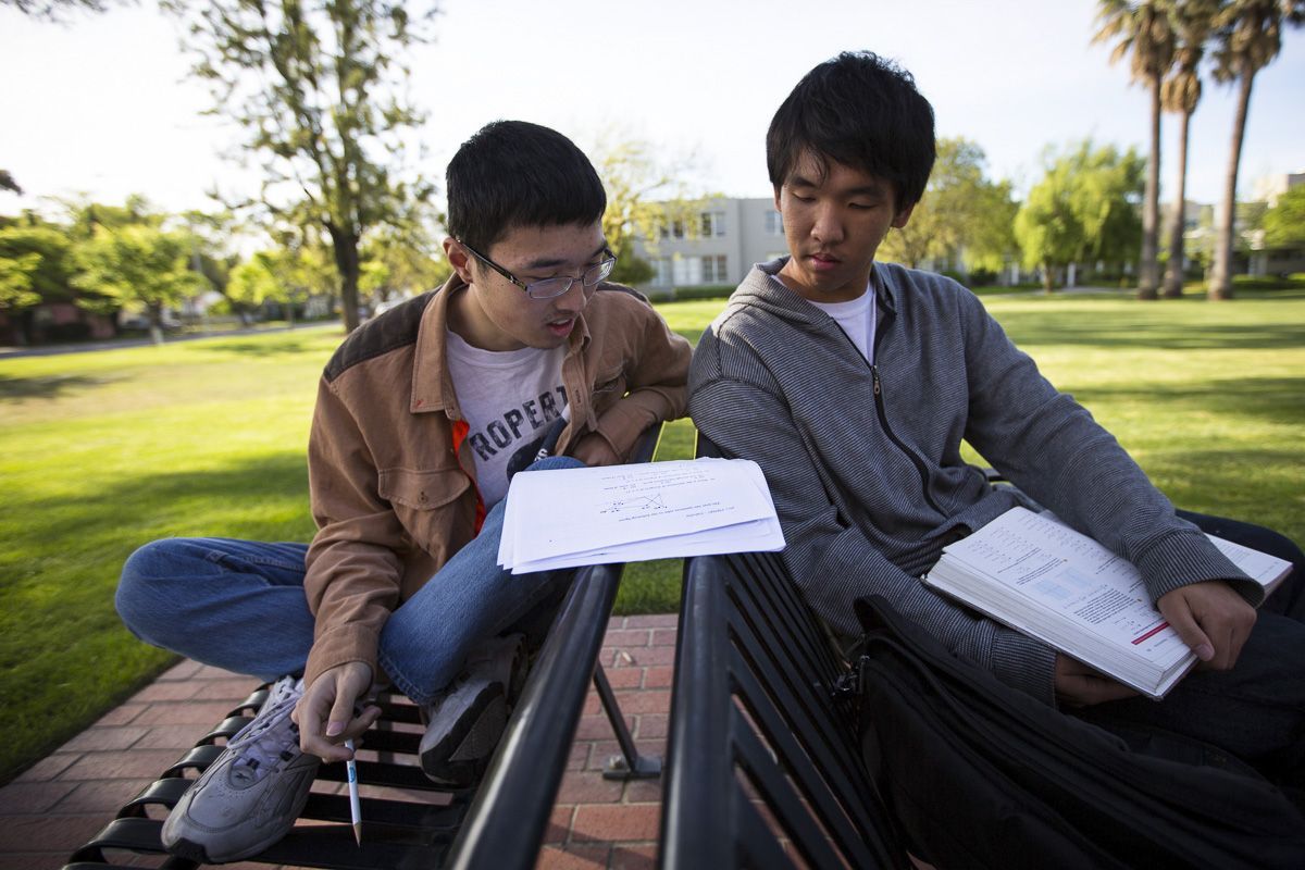 two students studying math together outside