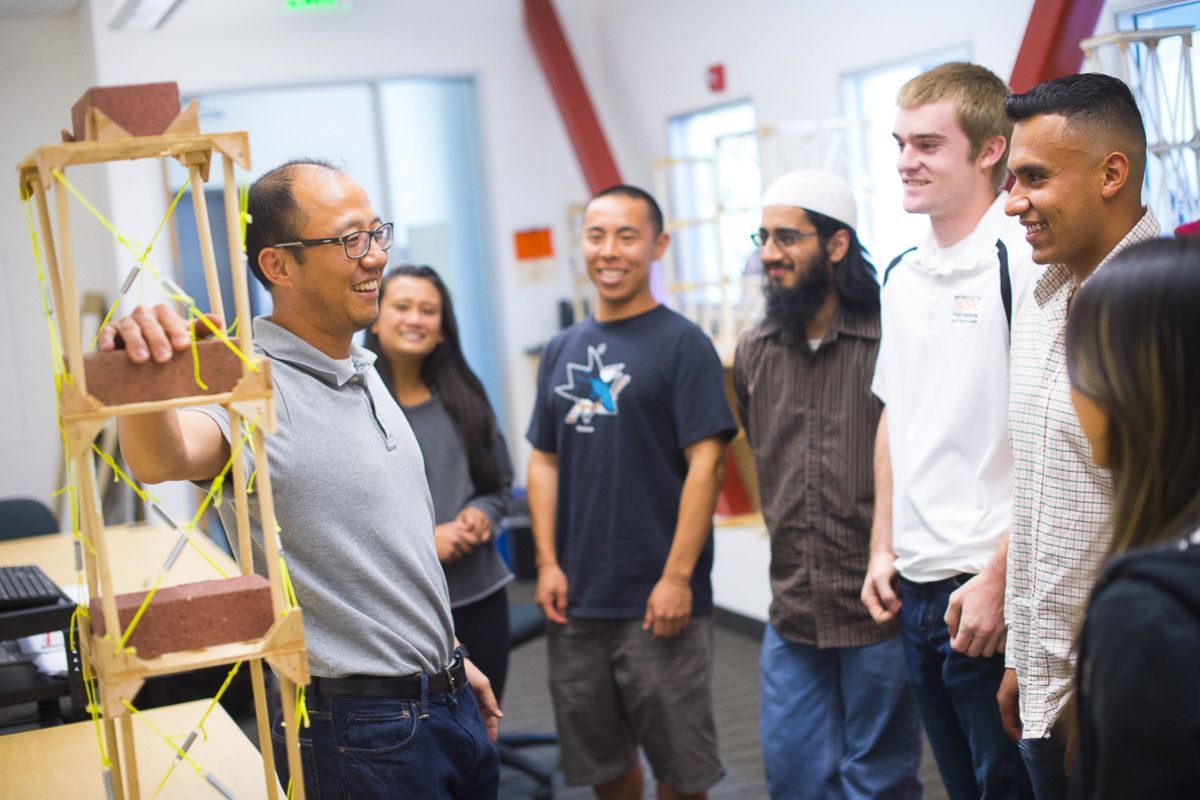 A professor talking with students in a lab.