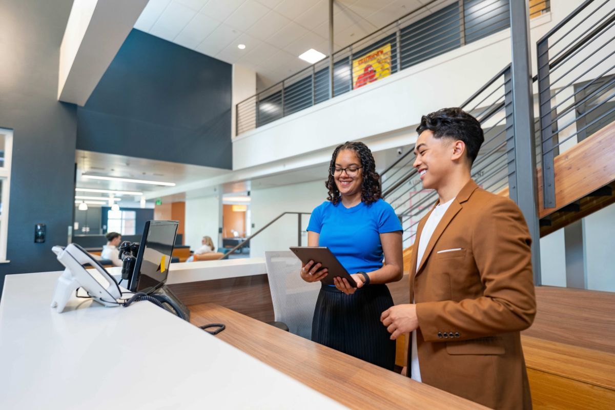 Two hospitality specialists at a reception desk 