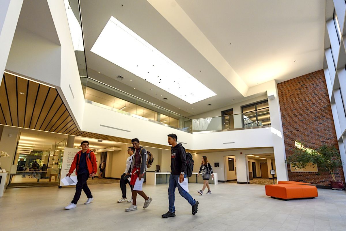 students walk through the lobby of the Library Learning Center