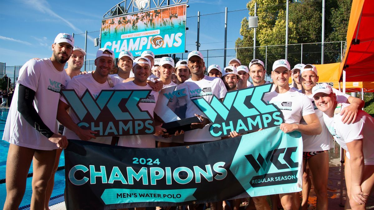 students pose for a picture holding a championship banner