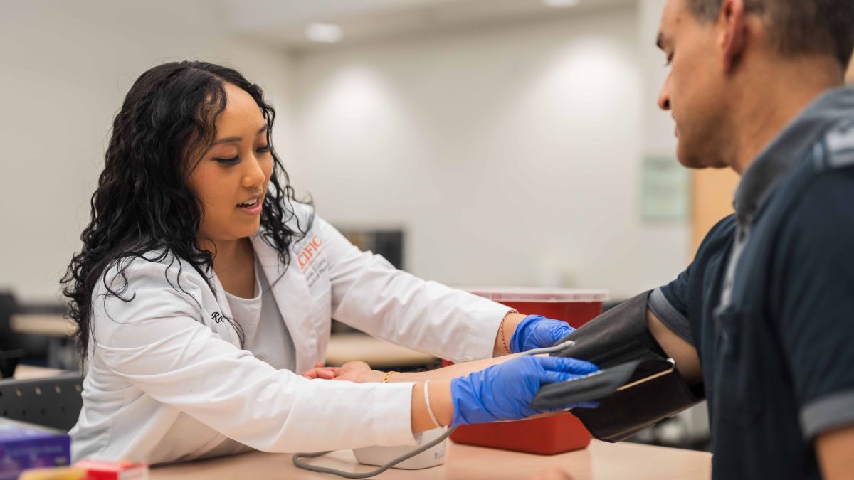 A student practices checking blood pressure
