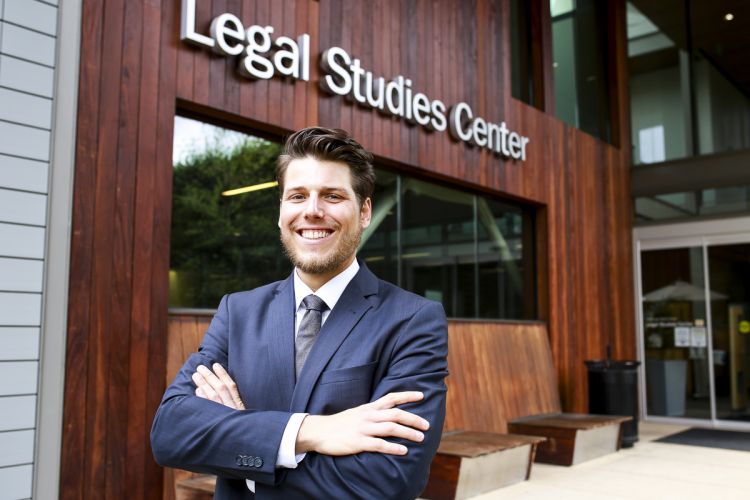 Heimo Weiss crosses his arms in a portrait in front of the library.