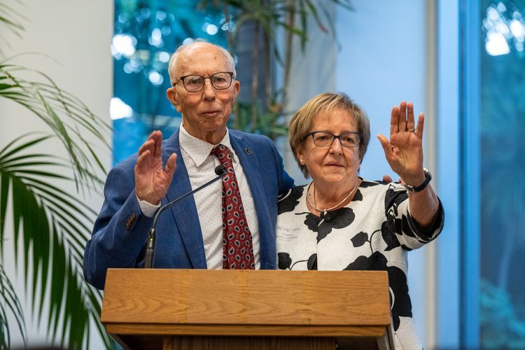 A couple poses for a photo at a podium.