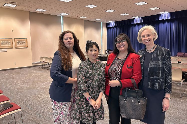 Four women pose for a photo indoors