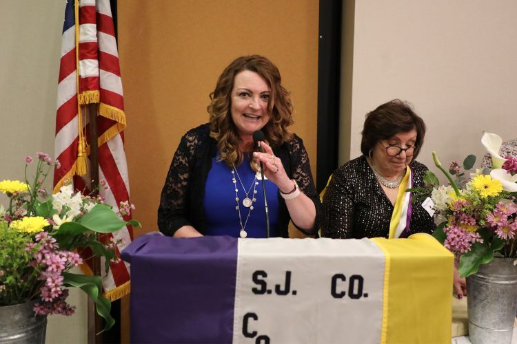 Elizabeth Orwin stands at a podium