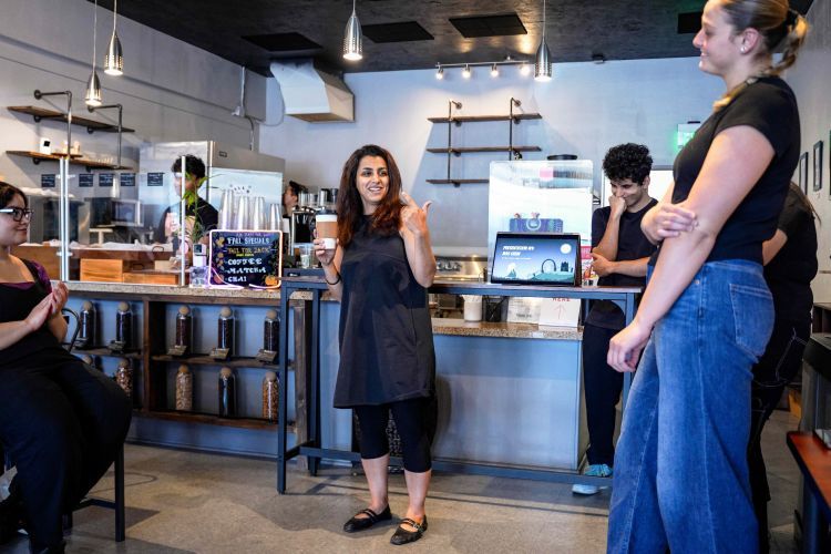 Professor Zoya Laskowski at Groundstack Coffee talking to students. 