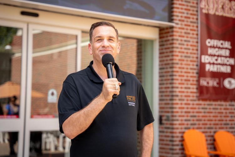 Josh O'Connor holding a microphone