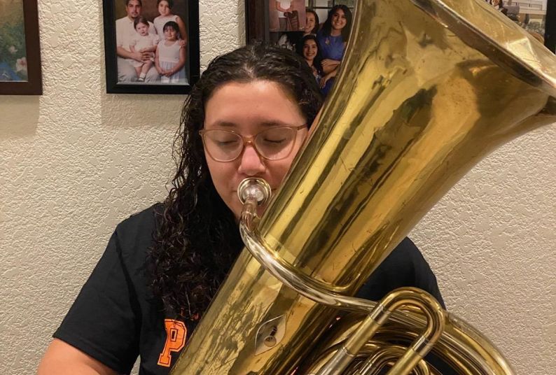 Jolene Villavicencio at home with the tuba the Conservatory of Music loaned her.