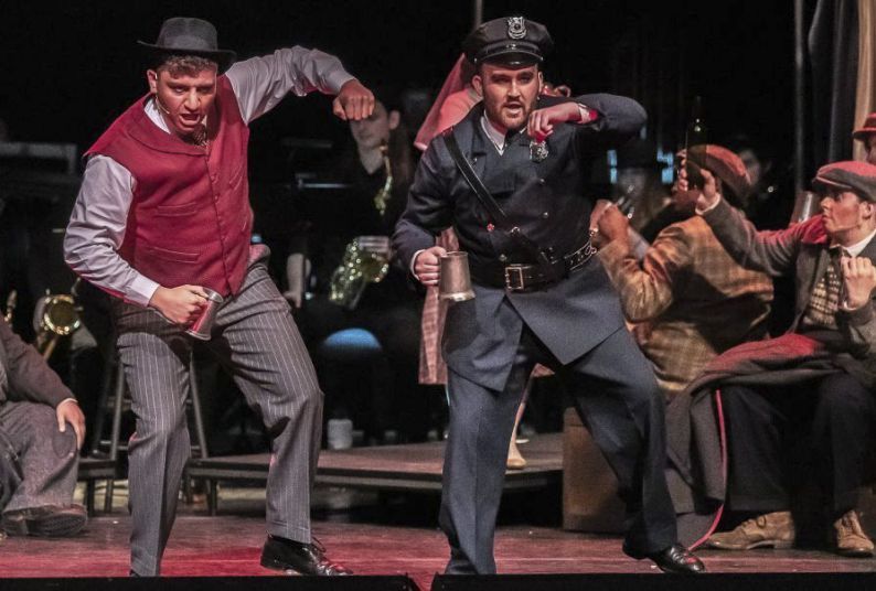 two students dance on stage during an opera production