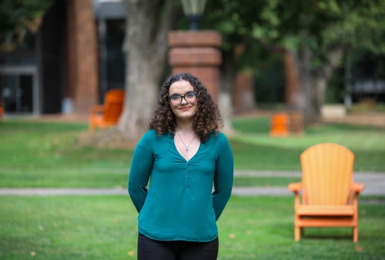 Picture of a female student in green shirt on campus.