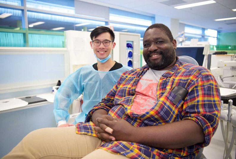 veteran in patient chair smiling with volunteer