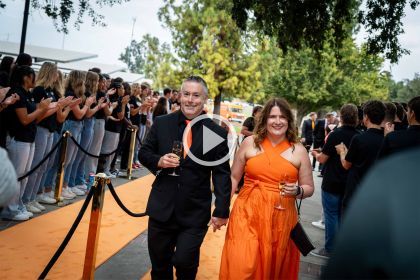 a couple walks the orange carpet at the Orange and Black ball