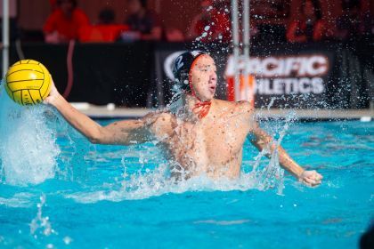 A waterpolo athlete throwing a ball in a pool.