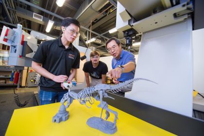 Students building dinosaur.