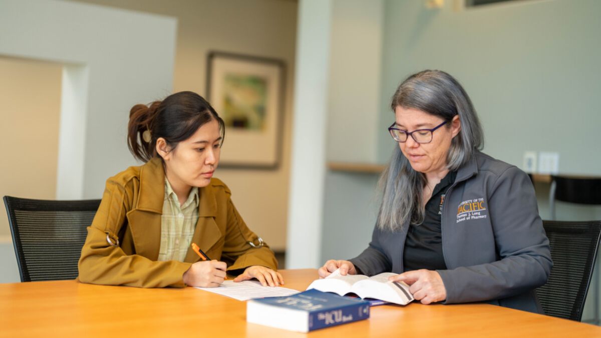 A student and a professor are seated at a table together